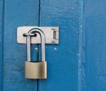 Blue door locked with a padlock