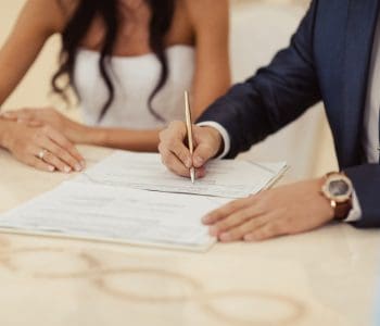 married couple signing wedding register at table